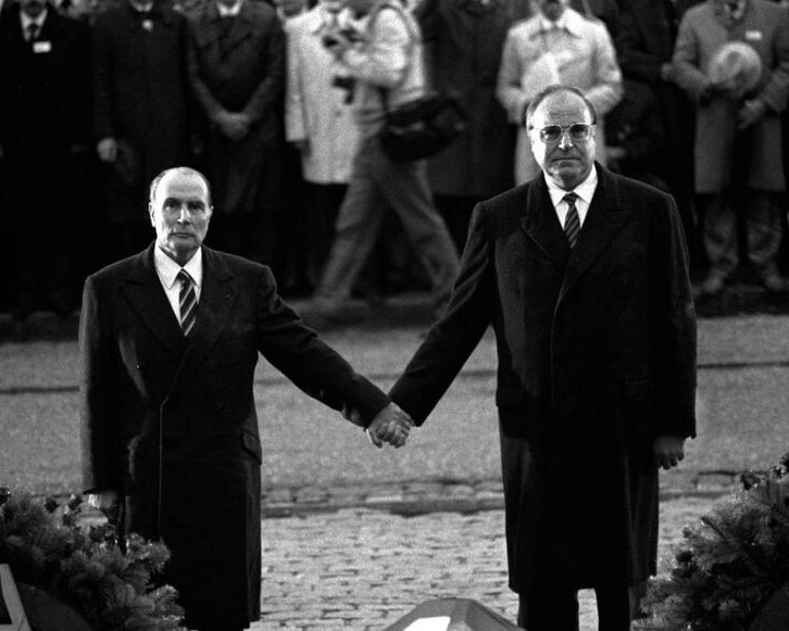 Chancellor Kohl and President Mitterrand standing hand in hand in front of a memorial wreath at the Douaumont Ossuary, Verdun, 1984